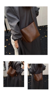 Detail view of a vintage brown leather bucket bag with side charm and minimalist strap