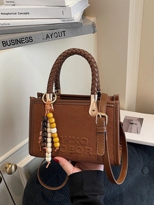 Minimalist brown suede handbag with woven handle and beaded tassel charm in retro style