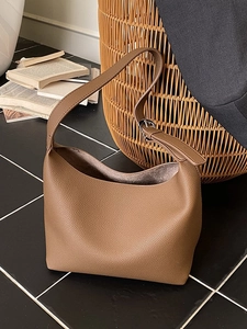 Brown lychee leather hobo bag with adjustable strap for women in a vintage setting