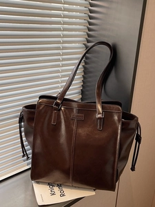 Glossy dark brown tote bag with shoulder straps and decorative side drawstrings