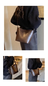 Close-up of brown PU leather bucket bag with textured finish and side buckle detail