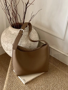 Brown grainy leather Hobo shoulder bag with adjustable silver buckle in a cozy setting