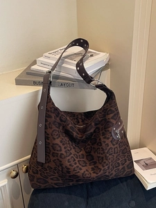 Chic leopard print oversized tote bag with metal eyelet strap in a minimalist setting