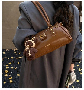 Braune glänzende Baguette-Tasche mit goldenen Beschlägen und süßem Bärenanhänger