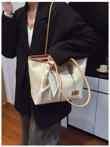Chic cream tote bag with brown trim and floral scarf detail shown on person for daily style