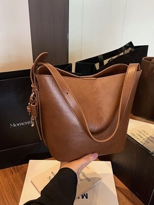 Brown vintage faux leather bucket bag with knot detail and spacious handheld design