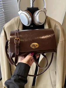 Vintage dark brown crossbody bag with glossy leather and gold buckle closure