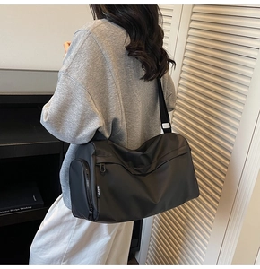 Practical black multi-layer crossbody bag with wide shoulder strap shown on a model
