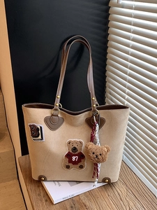 Retro kaki tote bag met teddybeer patch en pluche hanger in een gezellige omgeving