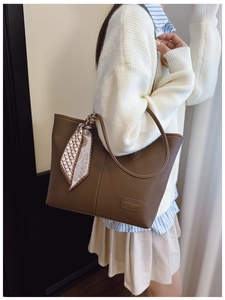 Close-up of brown PU leather tote bag with printed silk scarf and fashion leather label