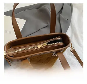 Close-up detail of smooth gold metal zipper and suede texture on brown bucket bag
