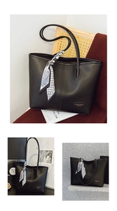 Detail view of black leather tote bag with geometric silk scarf and branded logo plaque