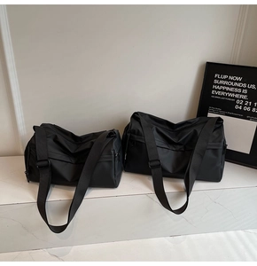 Comparison of black multi-layer nylon travel bags in two sizes on marble surface