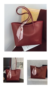 Detail of burgundy leather tote bag with decorative floral silk scarf and fashion logo