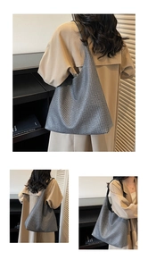 Detail view of large houndstooth tote bag featuring black leather strap and textured fabric