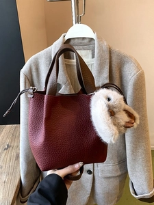 Sac seau chic en cuir grainé rouge avec poignées marron et charmant pendentif lapin en peluche