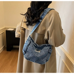 Side view of retro denim crossbody bag with adjustable strap and metal plate detail