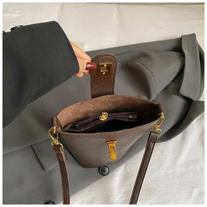 Brown leather bucket bag with gold clasp and inner zipper compartment for women