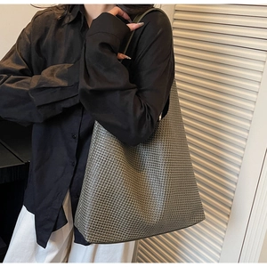 Side view of olive green woven leather tote bag shown on a model for daily commute