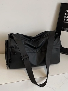 Large black multi-layer crossbody bag with adjustable strap on white marble surface
