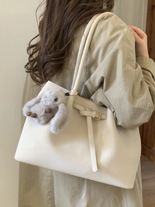 Sac fourre-tout minimaliste en daim beige avec charme lapin porté par le modèle