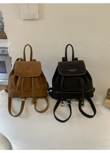 Dettaglio mini zaini in ecopelle marrone e nero con chiusura a coulisse e cuciture bianche