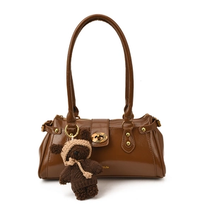 Bolso baguette de cuero brillante marrón con un colgante de oso y herrajes dorados