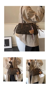 Detail of leopard print underarm bag with a brown plush bear charm and long leather strap