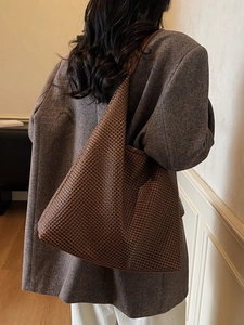 Large dark brown woven tote bag worn by model, minimalist hobo style for daily commuting