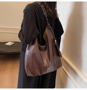 Détail du sac cabas en cuir marron foncé avec coutures contrastées sur l'épaule
