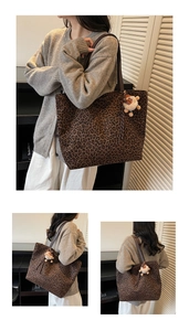 Close-up of leopard print tote bag with brown leather handles and plush lamb charm