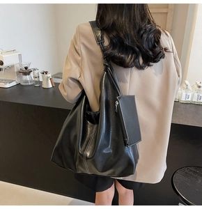 Détail du grand sac cabas noir en similicuir avec coutures blanches et petite pochette