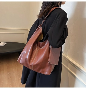 Vue détaillée du grand sac cabas en cuir souple marron avec pochette sur l'épaule