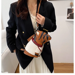 Detail of tiger-shaped shoulder bag featuring brown lychee leather and plush stitching