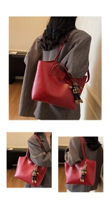 Detail of vintage red tote bag with bear charm and matte PU leather texture
