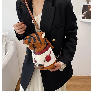 Detail of creative tiger crossbody bag worn by model with textured plush and faux leather