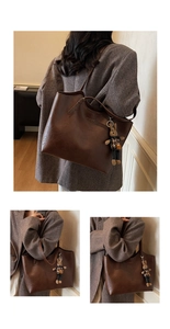 Detail of a large vintage brown tote bag with a leopard print rabbit doll charm