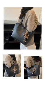 Detail view of large black tote bag with gold lettering and cute bunny plush charm