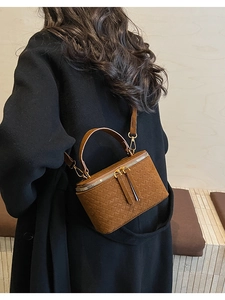 Brown woven leather vanity box bag with gold double zipper and cross-weave pattern