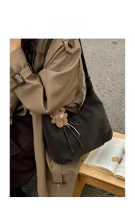 Sac fourre-tout en similicuir marron avec charm ours dans un décor d'automne chaleureux