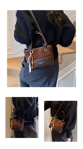Detail of retro dual-tone bucket bag with vintage wooden beads and detachable strap