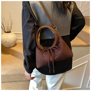 Detailed view of dark brown tote bag with fuzzy handles and a decorative bow tie