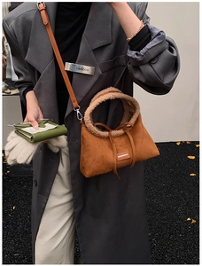 Detail of caramel suede tote with beige shearling trim and adjustable strap