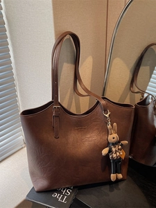 Vintage brown leather tote bag with rabbit charm and stylish fashion lettering on front