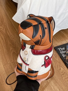 Cute orange tiger crossbody bag with white plush detail and delicate brown shoulder strap