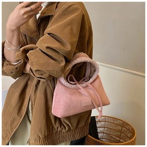 Detail of pink matte suede tote with plush shearling trim and bow tie decoration