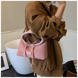 Detail of light pink suede tote bag with faux fur trim and bow knot decoration