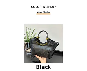 Dettaglio della borsa a secchiello in pelle nera con cuciture e decorazione a catena oro