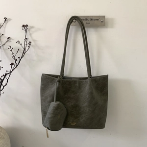 Detalle del bolso tote gris grande con monedero redondo y logotipo dorado