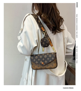 Detailed side view of a brown vintage monogram crossbody bag with a wide strap on a model